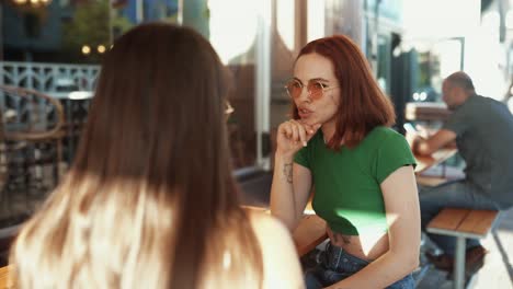 amigas hablando en un café al aire libre.
