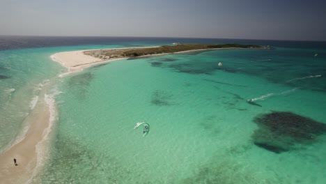 Turquoise-waters-and-kitesurfers-at-cayo-de-agua,-los-roques,-aerial-view