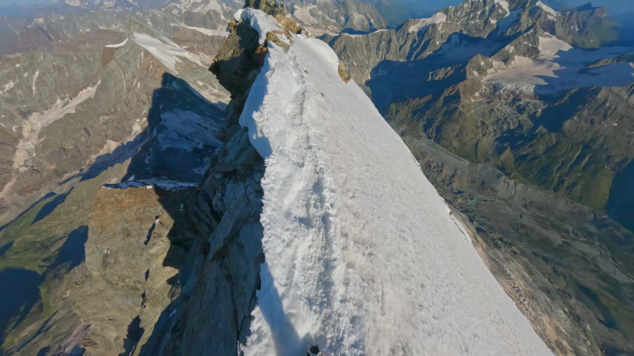 First-person POV of a climber ascending the iconic Matterhorn at sunrise on a crystal-clear bluebird day. Captured on GoPro for an immersive, realistic mountaineering experience above the clouds
