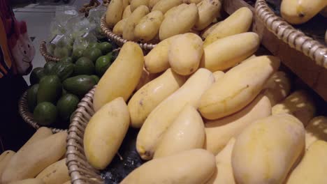 Panning-camera-over-the-fruit-shelf-stall-in-supermarket-with-many-kind-of-mangoes-on-stall