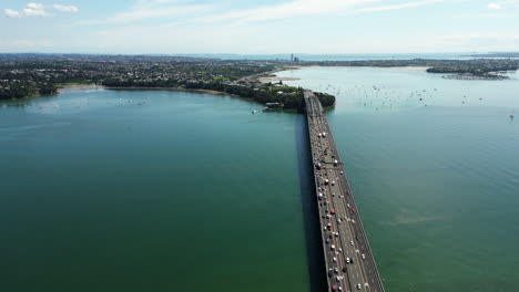 aerial-view-of-Auckland-bridge-over-the-ocean-in-NZ-New-Zealand-with-traffic-cars-during-a-sunny-day-of-summer,-public-infrastructure