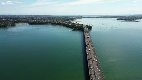 vista aérea del puente de auckland sobre el océano en nz nueva zelanda con vehículos de tráfico durante un día soleado de verano, infraestructura pública