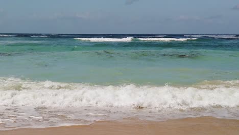 slow motion beach waves for very long time filmed 4k camera. beautiful sandy summer sun light waves crushing and splashing on shore beach. amazing tropical landscape with ocean blue in background.