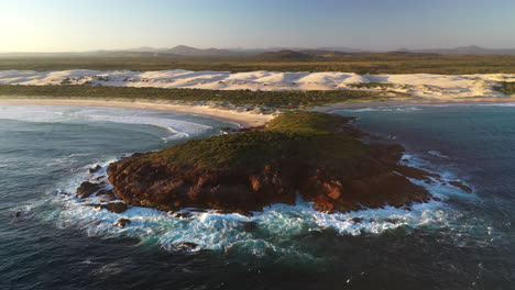 rotating drone shot of broughton island at the dark point sand dunes at hawks nest, new south wales, australia