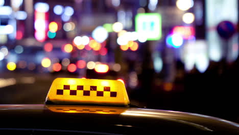 Timelapse-of-city-traffic-at-night-behind-taxi-sign