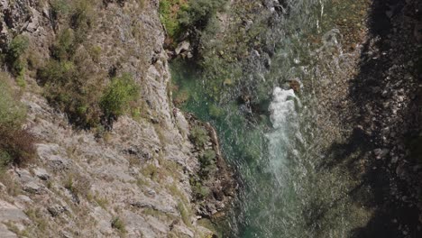high angle view of clear river flowing in rocky valley - sunny day