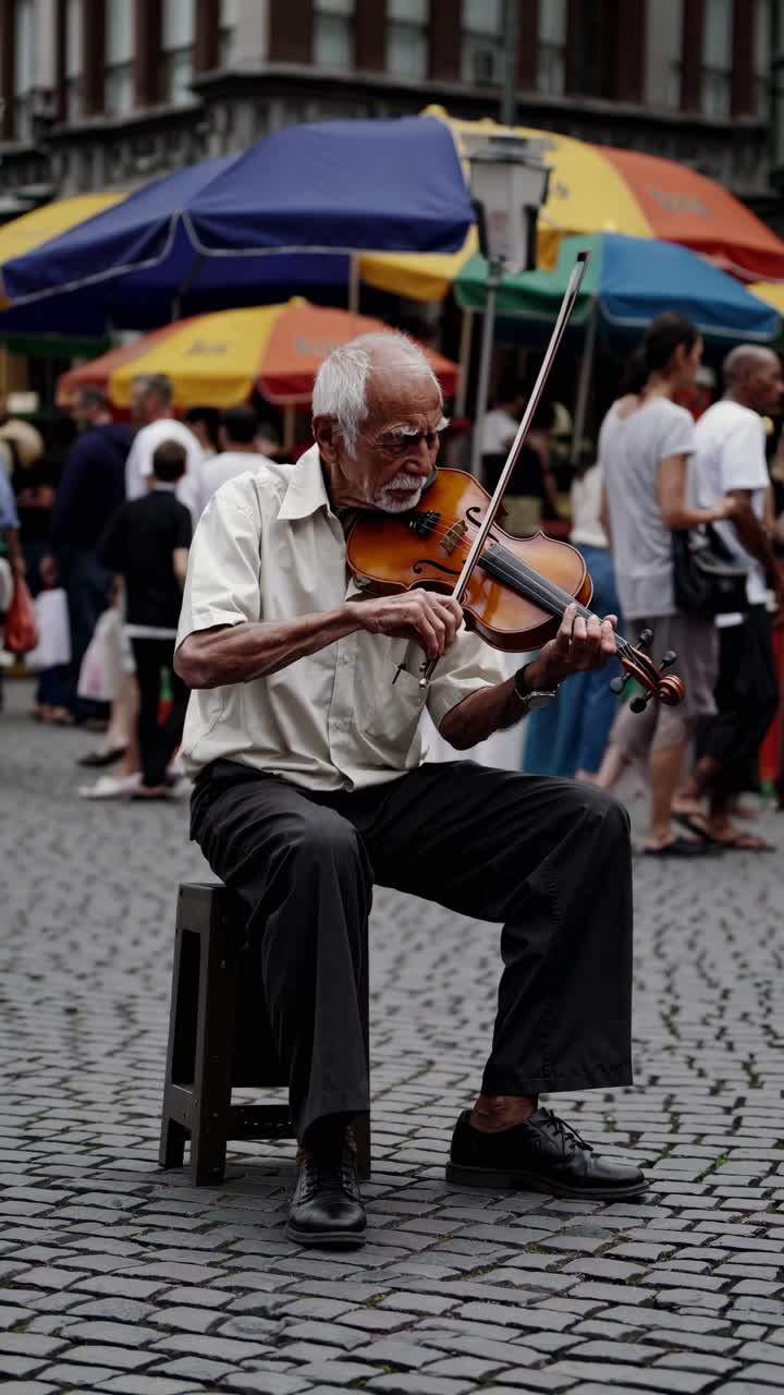 Músico de rua tocando violino sentado em um banquinho, capturado na altura dos olhos