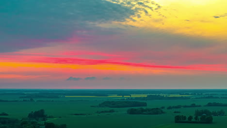 clouds and vibrant skies over the green landscape of countryside. - timelapse shot