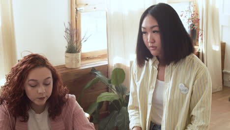 young woman discussing ideas with her two colleagues during a team meeting 1