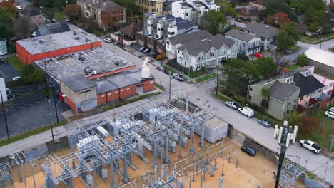drone view that reveals electricity station surrounding by homes in neighborhood