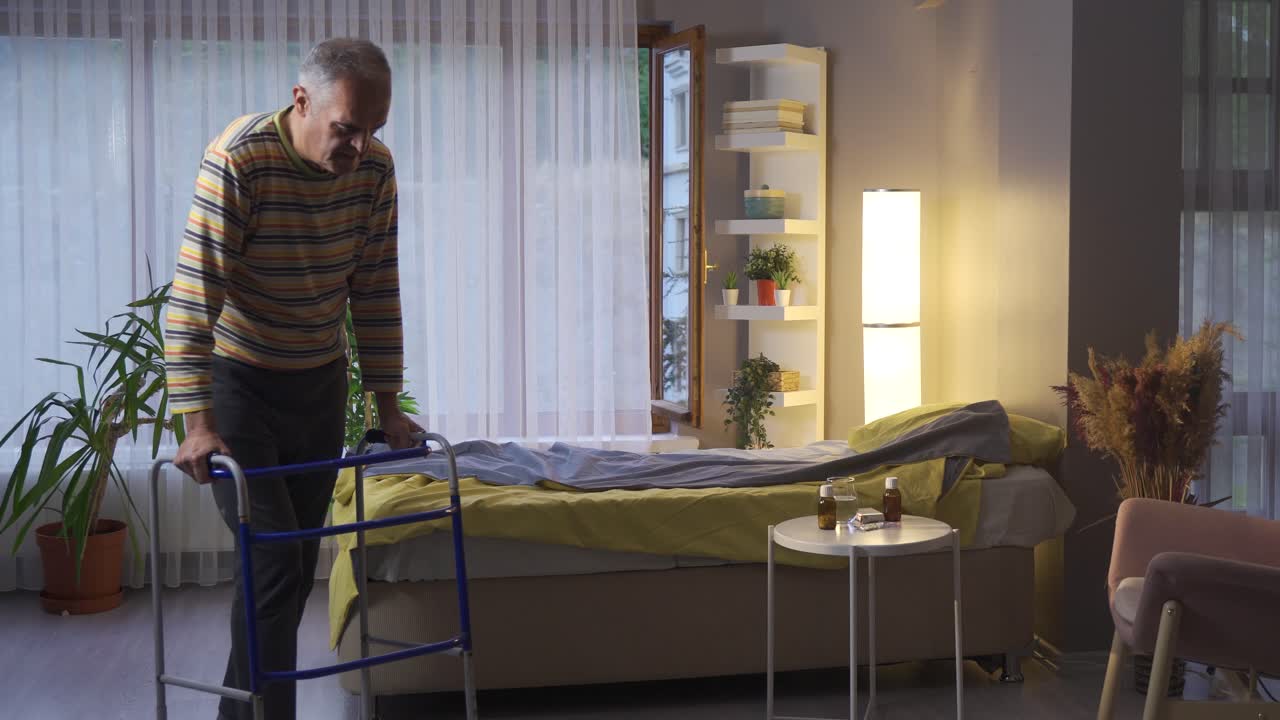 병든 남자가 워커와 함께 집에서 혼자  ⁇ 고 있습니다.