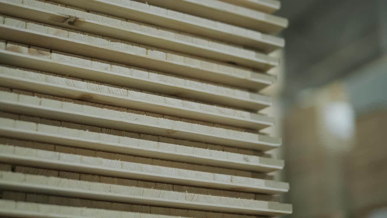 Detailní záběr naskládaných dřevěných prken ve skladu
