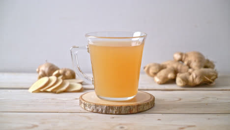 vaso de jugo de jengibre fresco y caliente con raíces de jengibre - estilo de bebida saludable