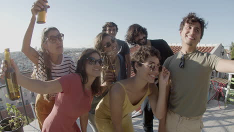 grupo de amigos felices tomando selfie durante una fiesta en la azotea