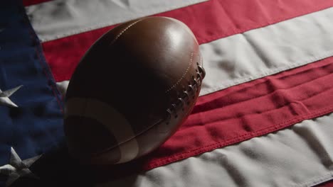 low key lighting studio shot of american football on stars and stripes flag 10