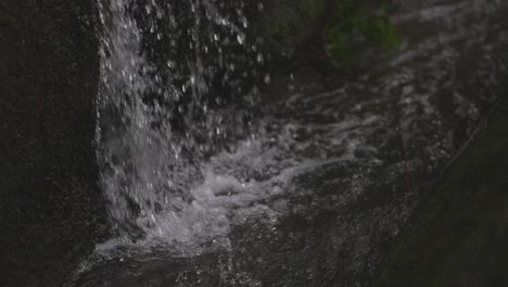 un pequeño riachuelo se está cayendo a un riachuelo más grande