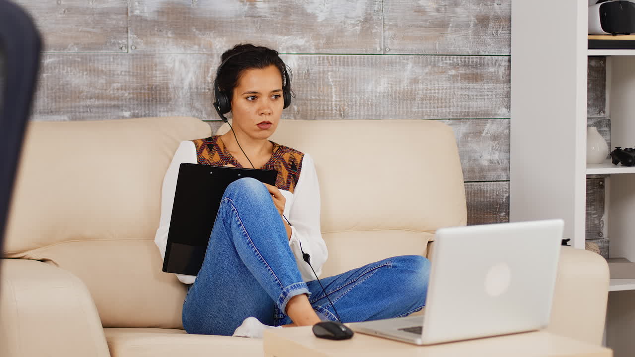 헤드폰 을 든 여자 가 클립보드 에 메모 를 쓰고 있다