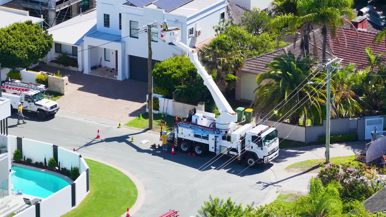 Dronebillede af en servicelastbil og en arbejder, der udfører vedligeholdelse på elledninger i Australien.
