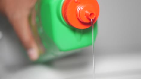 pouring liquid from a green bottle