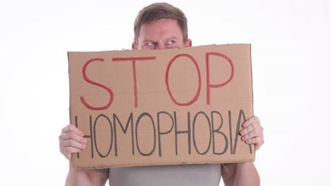 man holding a 'stop homophobia' sign