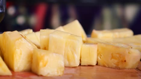 piña en cubos en una tabla de cortar de madera