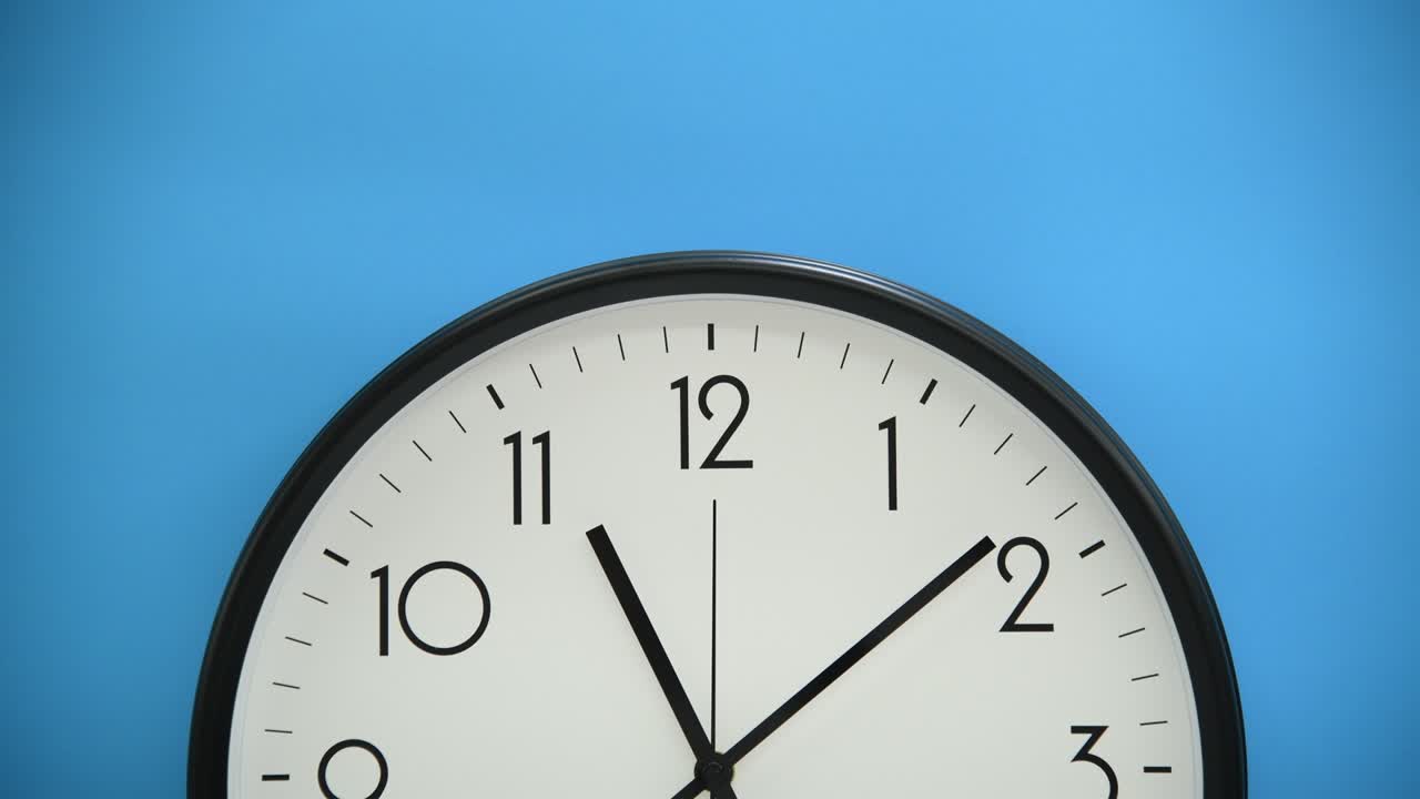 Black wall clock on blue background