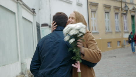 man meeting beloved woman with flowers