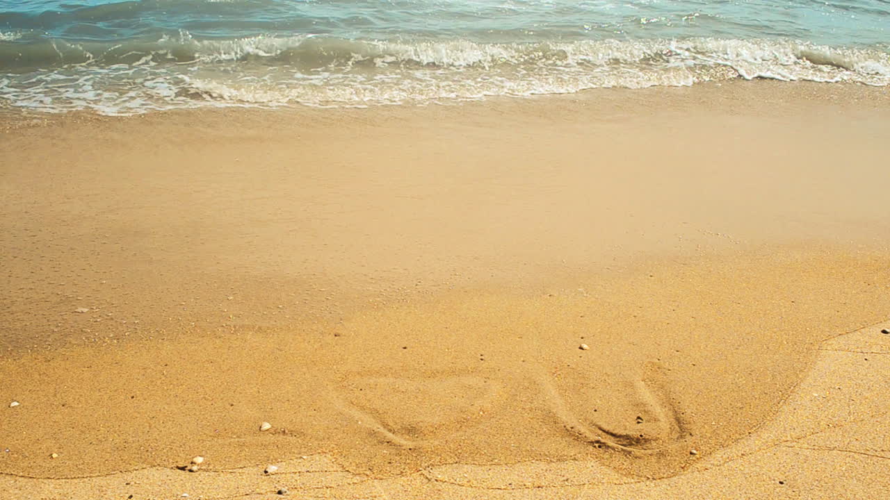 „Ich liebe dich“-Inschrift im Sand. Aufnahmen am Strand.