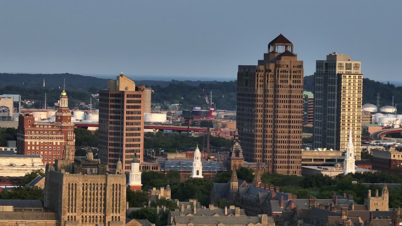 Downtown of New Haven lighting at sunset. Aerial zoom shot. 360 State Street And Connecticut financial center tower in city. Peaceful evening in summer. Historic church towers in town
