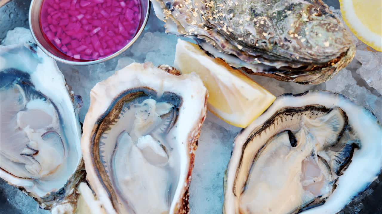 Close up of a bucket with raw oyster with lemons on ice at a restaurant