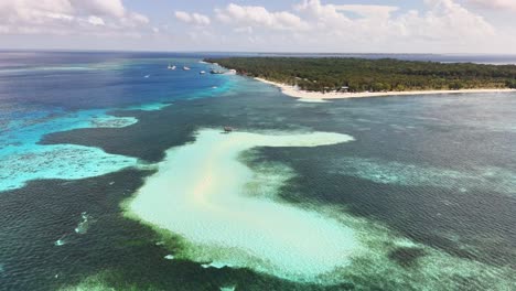 drone footage reveals candaraman sand bar in balabac, palawan, a stunning stretch of white sand surrounded by vibrant coral reefs, shallow turquoise waters, rich in marine biodiversity