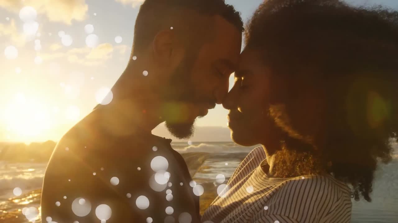 momento de complicidad en la playa entre una pareja de raza mixta