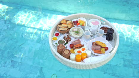 top view on breakfast food tray floating on pool water