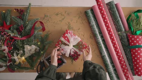 mejor regalo de navidad. las manos de la mujer sosteniendo una caja de regalos de artesanía vacía, preparando una sorpresa para las vacaciones, vista superior