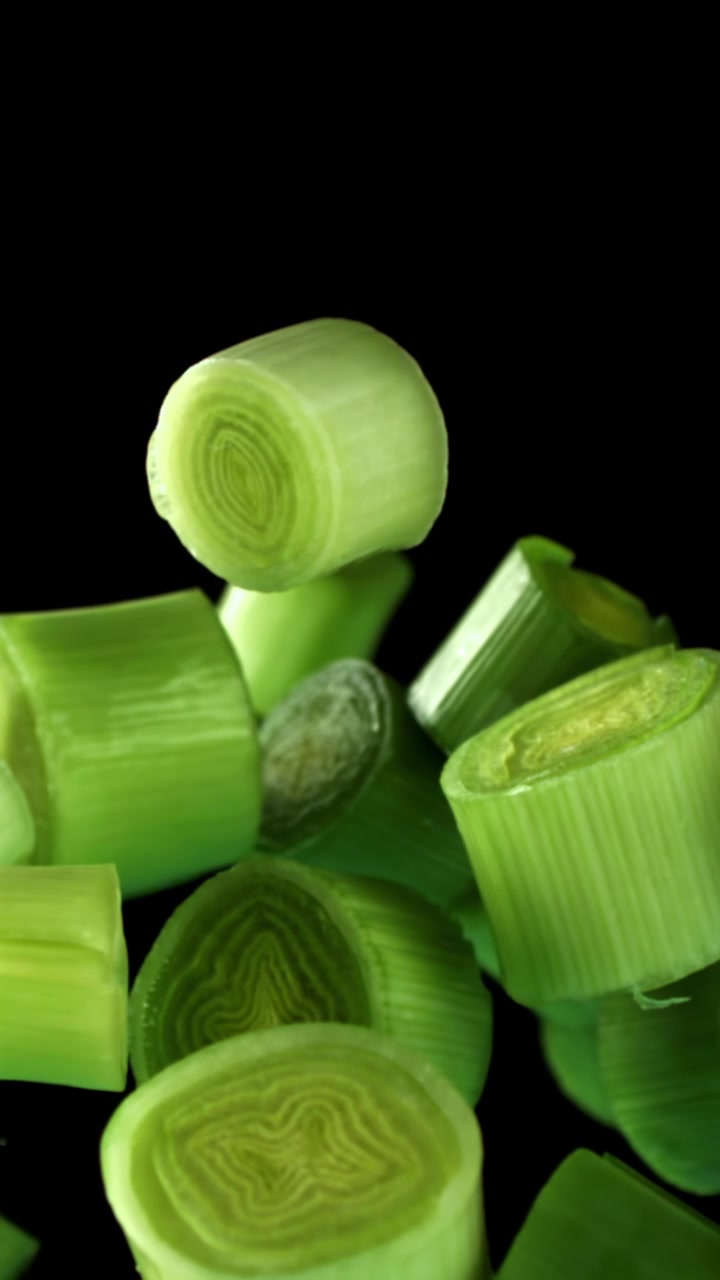 Cipollotti tritati verde brillante che cadono al rallentatore