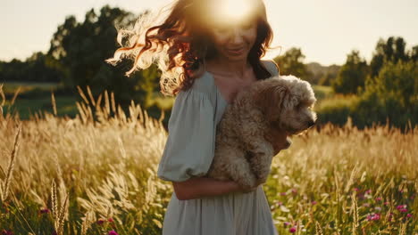 woman and her dog walking in a sunlit golden field