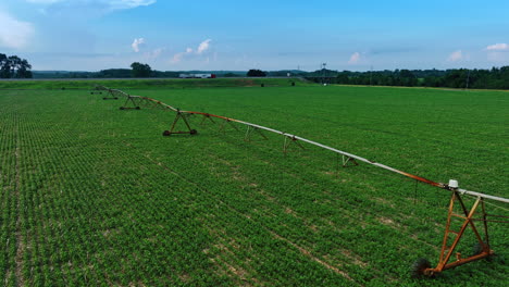 green field with the construction for irrigating the crops. agricultural concept. trucks move by the highway at backdrop.
