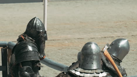 slow motion shot of knights fighting with hatchet during sunny day