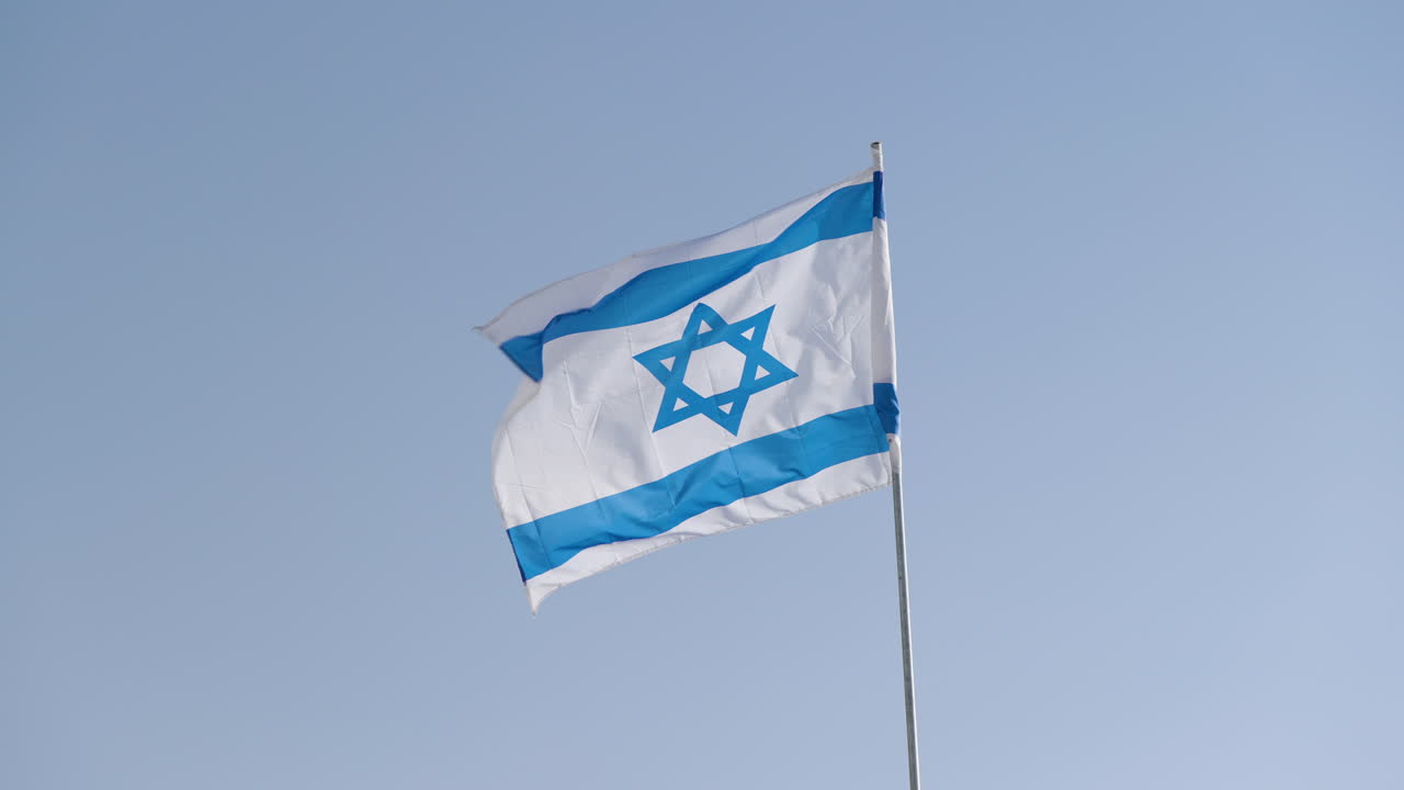 Bandiera nazionale di Israele che sventola al vento contro il cielo blu.
