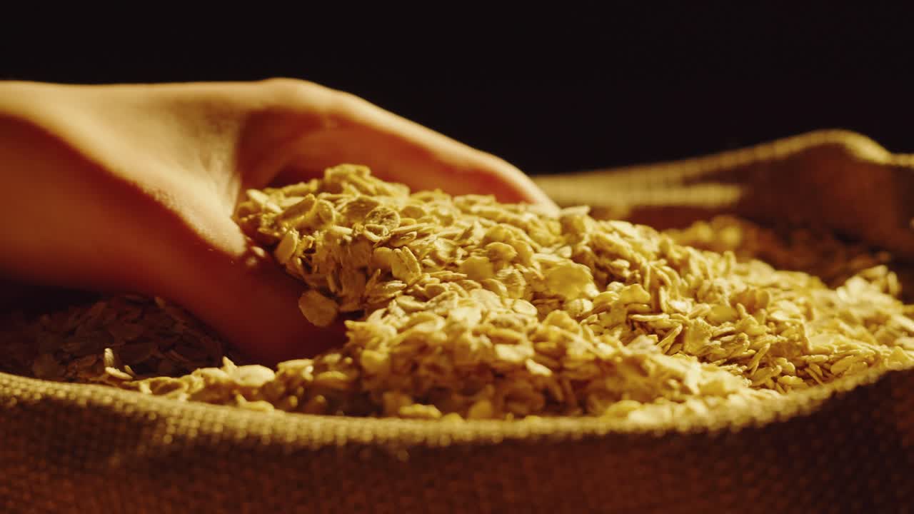 Close-up of Hand Pouring Oats into a Sack