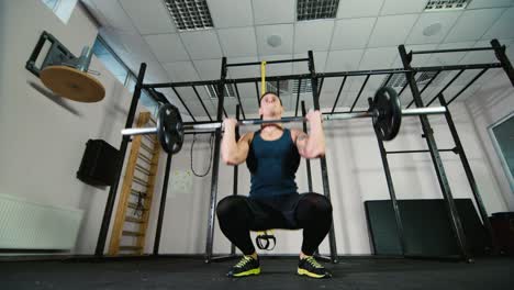 atleta entrena con una barra en el gimnasio
