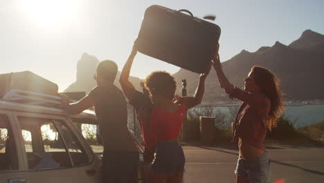 Friends-Loading-Luggage-Onto-Car-Roof-Rack-Ready-For-Road-Trip