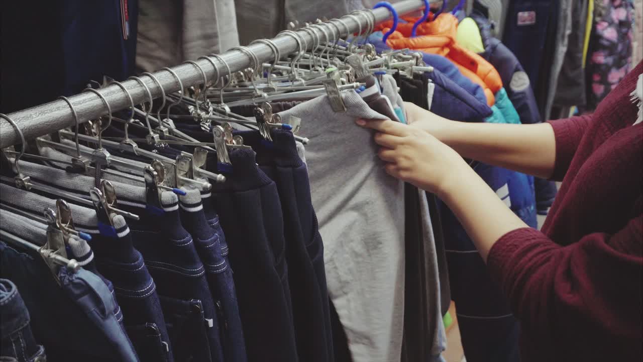 Woman shopping for children's pants in a clothing store
