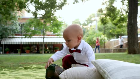 curious baby gets up and run barefoot on green grass at park in slow motion