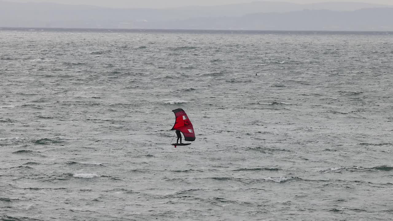 persona haciendo windsurf en el mar en fife, escocia