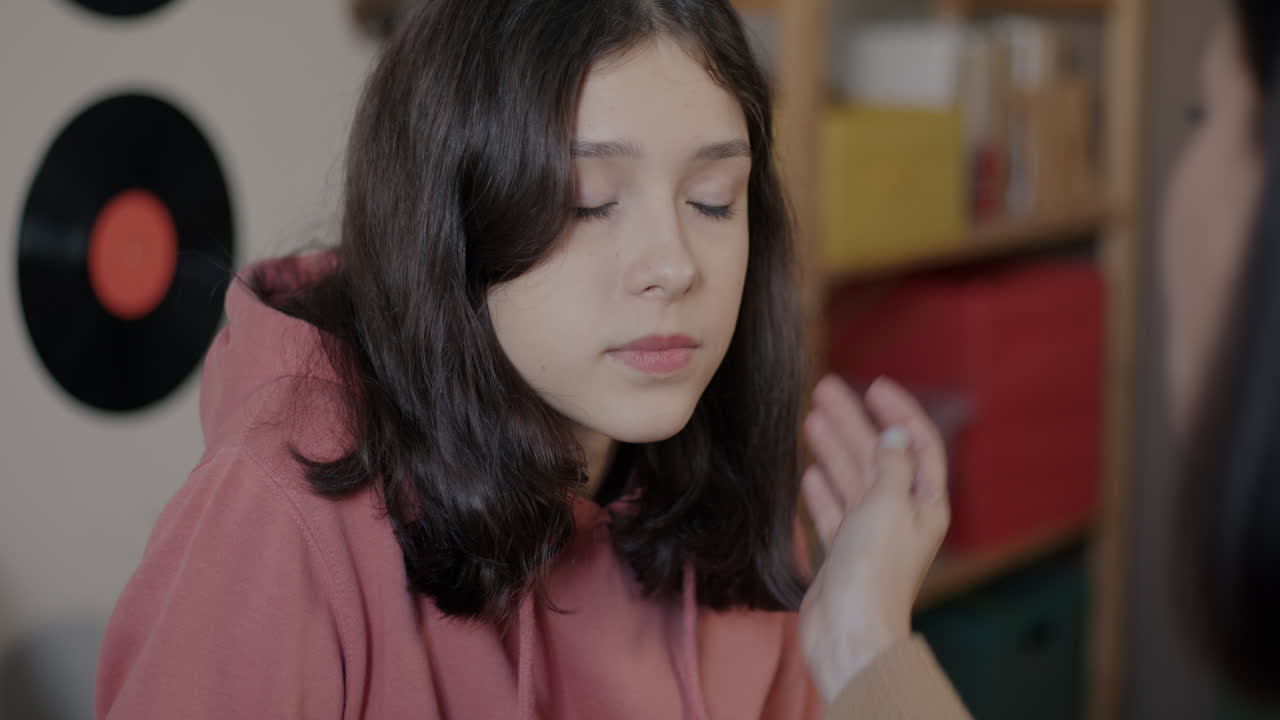 Teenage girl getting makeup applied