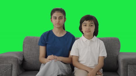 hermano indio serio mirando fijamente a la cámara pantalla verde