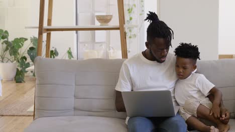 Father and son using technology together at home