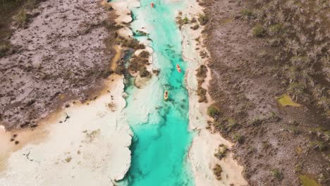 upwards panning drone shot of kayakers revealing the scenic view of "los rapidos" rapids located in bacalar, mexico shot in 4k