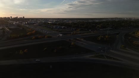 Vista-Aérea-De-La-Ciudad-Durante-La-Puesta-De-Sol-Con-Carreteras-Que-Se-Cruzan